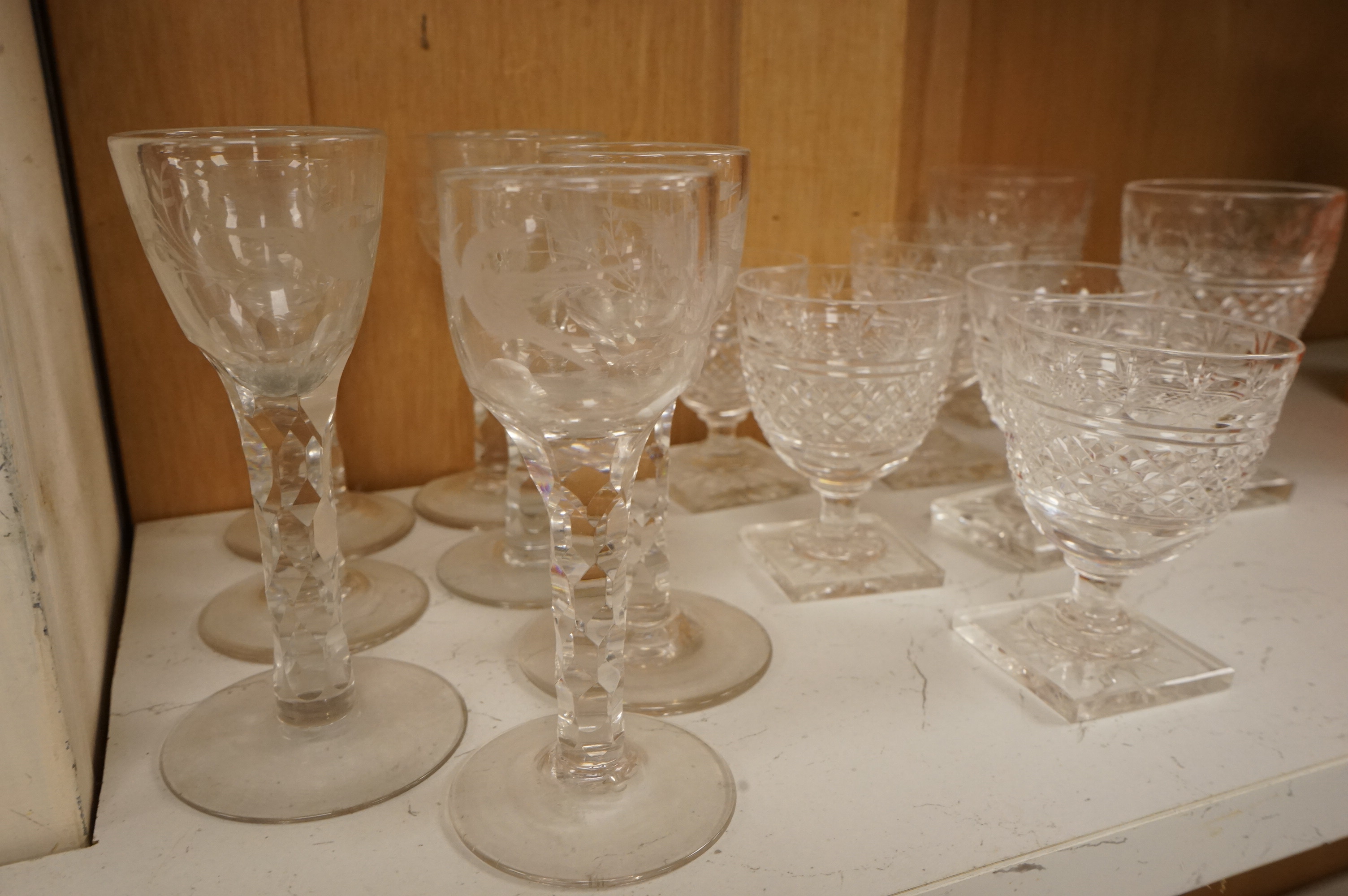 Seven Georgian style facet stem engraved wine glasses and a part suite of 19th centuy rummers, largest 14cm high